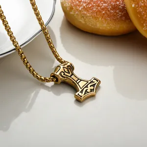 Macro shot of vintage gold Thor's hammer Mjölnir pendant with nordic engraving