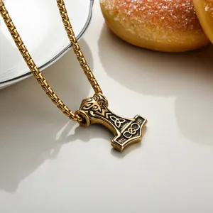 Detail of golden Thor's Hammer pendant with Celtic patterns on a sturdy box chain