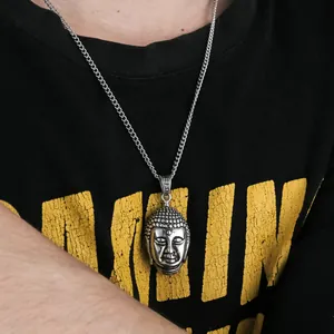 Detailed close-up of a vintage silver Buddha head pendant with intricate metallic textures