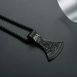 Macro shot of black Viking battle axe pendant with Nordic engravings and box chain