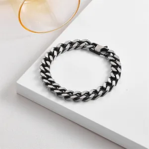 Close-up of a rugged gunmetal Cuban curb chain bracelet with secure lobster clasp