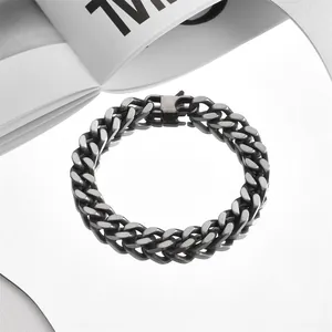 Close-up of thick silver Cuban link bracelet with industrial buckle on white surface