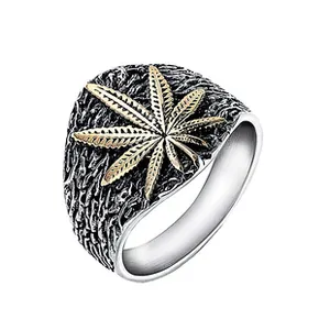 Macro detail of retro stainless steel ring featuring golden leaf relief and textured finish