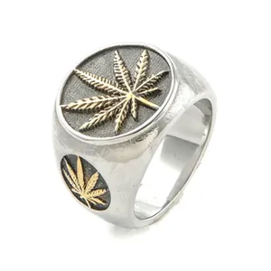 Macro detail of vintage stainless steel signet ring with golden leaf pattern and dark background