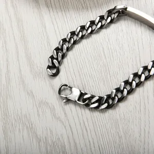 Macro detail of retro stainless steel curb chain bracelet with lobster clasp on wood