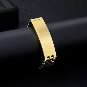 Gros plan d'un bracelet bicolore en acier inoxydable avec une plaque polie dorée