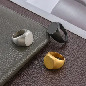 Men's square signet rings in silver, black, and gold finish on leather background