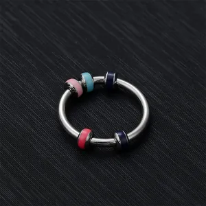 Detail eines Anti-Angst-Rings mit fünf bunten Emaille-Perlen auf Silberband