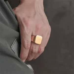 Detailed view of men's gold stainless steel signet ring with a matte square flat top