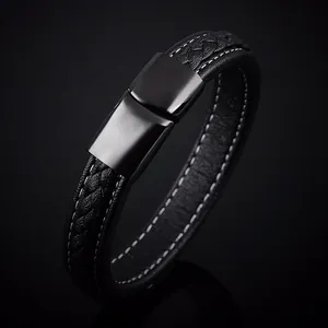Détail d'un bracelet en cuir noir avec surpiqûres blanches et fermoir magnétique en métal
