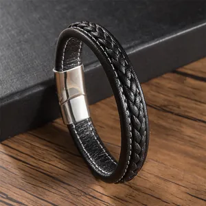 Détail d'un bracelet en cuir tressé noir avec surpiqûres blanches et fermoir magnétique