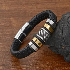 Herren Armband aus schwarzem Ledergeflecht mit Edelstahlringen in Gold und Silber auf Holz