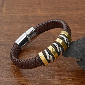 Detail of dark brown braided leather bracelet with gold, silver rings and magnetic clasp