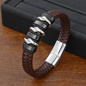 Men's braided leather bracelet with steel rings and magnetic clasp on wooden desk