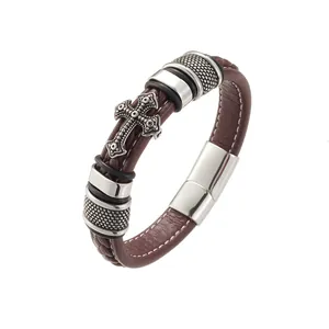 Close-up of brown braided leather bracelet with silver cross and magnetic clasp