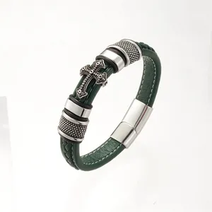 Detail of dark green braided leather bracelet with silver metal cross and magnetic clasp