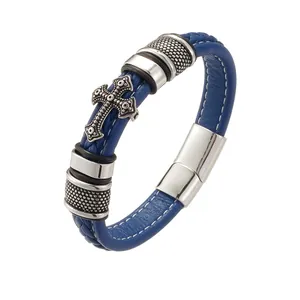 Detail of blue braided leather bracelet featuring a vintage metal cross and magnetic clasp