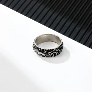 Macro shot of vintage titanium steel ring featuring detailed mountain forest and wolf relief