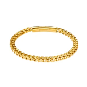 Detailed macro view of the gold wheat chain texture and polished cylindrical clasp