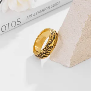 Detail of vintage golden viking wolf relief ring resting on a textured stone prop