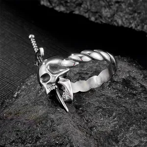 Vintage stainless steel gothic skull ring with sword detail on black stone background
