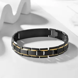 Detail of black and gold titanium steel link bracelet with matte finish on white stone