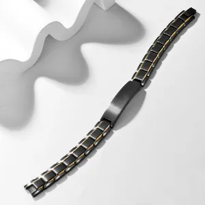 Detail of matte black and gold stainless steel bracelet with engravable curved nameplate
