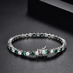 Close-up of white and emerald zircon tennis bracelet with a double safety clasp