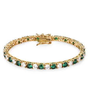 Detail of gold tennis bracelet featuring green and white stones with double safety clasp