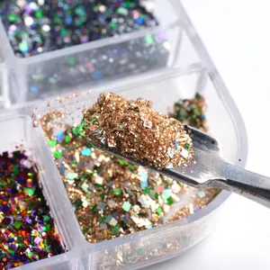 Macro detail of mixed nail glitter and sequins in a 6-grid box with metal tool