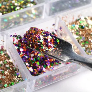 Macro view of colorful nail glitter mix and sequins with a metal application tool