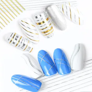 Macro detail of 3D rose gold and silver nail tape applied on blue and white manicure