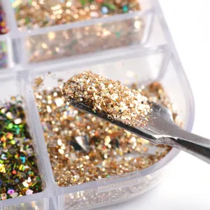 Macro shot of silver spatula picking up vibrant gold nail glitter from a 6-grid box