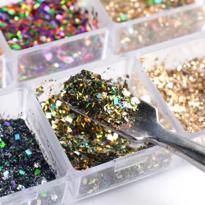 Macro shot of colorful iridescent nail art glitter and sequins with metal application tool