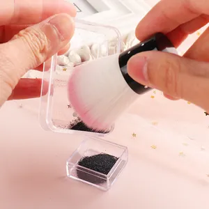 Close-up of pink ombre nail dust brush with rhinestone handle and clear storage box