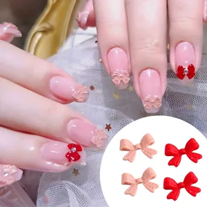 Decorazioni unghie a fiocco 3D in resina opaca rosa e rossa con strass su sfondo pizzo