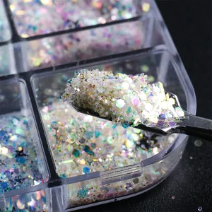 Dettaglio macro di glitter iridescenti per unghie con spatola in metallo in box