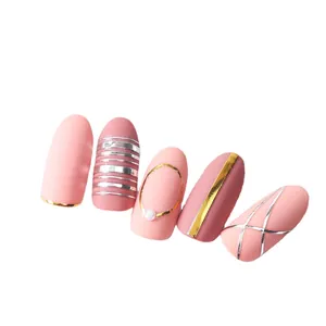Matte pink almond press-on nails with metallic gold lines and elegant pearl accents