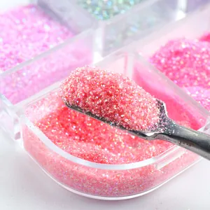 Macro detail of coral pink nail art glitter powder with shimmering particles in a box