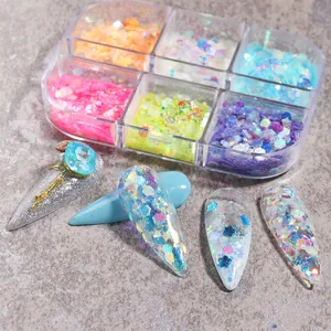 Makroaufnahme von sechsteiligen Nagelglitzer-Set mit Leuchtpailletten und Muster-Nageltipps