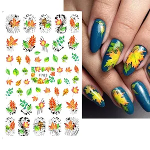 Macro detail of autumn maple leaf nail stickers with realistic application on blue nails