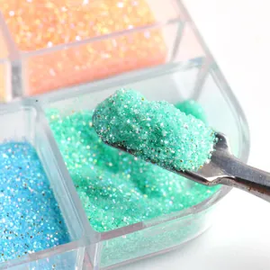 Macro shot of mint green nail glitter powder on a metal spatula with colorful set