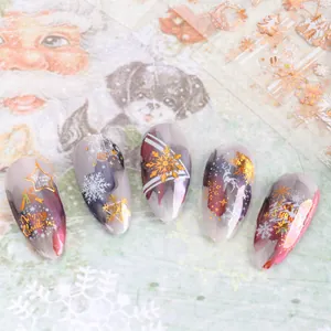Detail of Christmas nail stickers with gold metallic snowflakes and elk on festive nails
