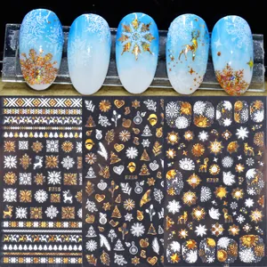 Detail of 3D Christmas nail stickers with gold and white snowflakes and reindeer designs