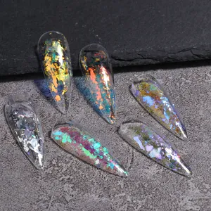 Detalle macro de uñas postizas almendradas con láminas iridiscentes aurora y purpurina