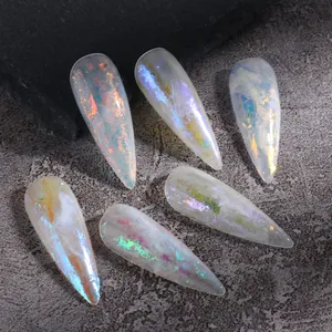 Vista macro de uñas stiletto aurora con escamas de opale iridiscentes sobre piedra