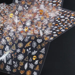 Macro shot of 3D embossed Christmas nail stickers featuring gold and silver snowflakes