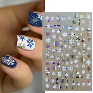 Detail van 3D sneeuwvlok nagelstickers met strassteentjes op donkerblauwe manicure
