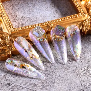 Detalle de dijes para uñas aurora púrpura con cristales 3D y copos de oro fino