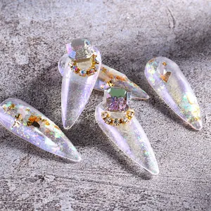 Nahaufnahme von Stiletto-Nägeln mit Aurora-Glitzer und 3D-Kristall-Verzierung